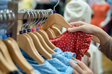 A women is choosing new clothes, shopping in fashion mall, close up of hands