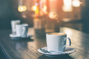 cup cappuccino coffee on wood table and vintage life stlye.