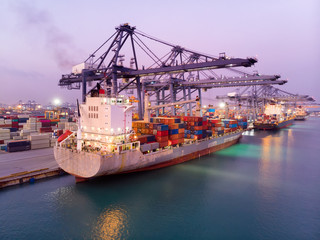Fototapeta premium Cargo ship carrying container and smart crane loading big tank for export import from cargo yard port to open ocean concept freight shipping at container depot. forwarder mast