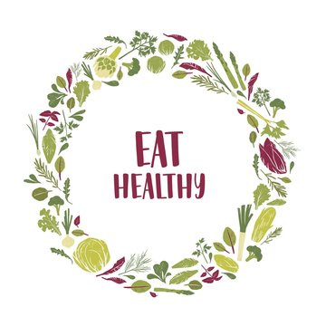 Wreath made of green plants, salad leaves, vegetables, herbs and Eat Healthy slogan inside