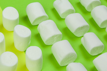 sweet marshmallow, candy on green background, top view