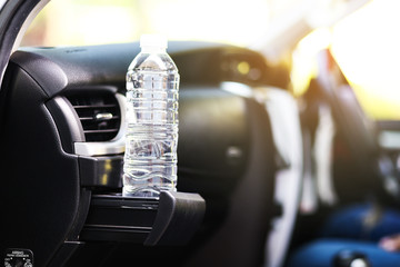 Place of coffee or tea mugs or bottle on the vehicle console in modern luxury car interior.
Water bottle placed on the car.
