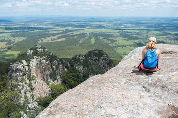 Fototapeta na wymiar Young beautiful woman looking out over the Australian landscape from the top of a mountain