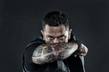 Tattooed elbow hide male face. Masculinity and brutality. Tattoo culture concept. Man brutal...