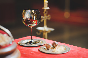 glass of red wine on wooden table in church