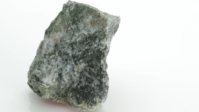 The pyroxenes are a group of important rock-forming inosilicate minerals stone, from Vesuvius volcano, isolated on a white background, Naples, Italy