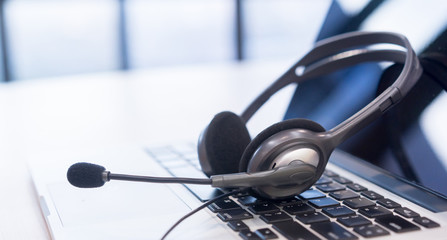 close up soft focus headphone call centre hotline at computer office help desk for background...