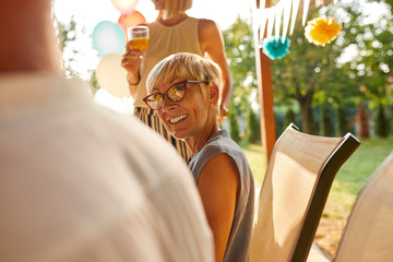 Smiling mature woman looking at husband on a garden party