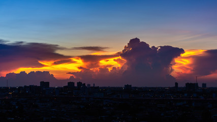 Dramatic clouds and sky of sunset over dark city