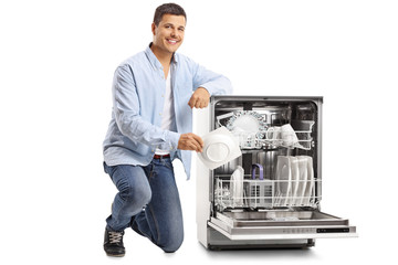 Young man putting a plate in a dishwasher
