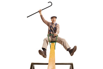 Senior man sittimg on a seesaw and holding a cane up