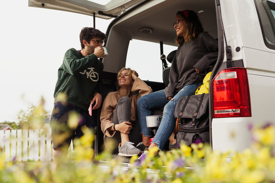 Friends sitting in a camper, taking a break, drinking coffee