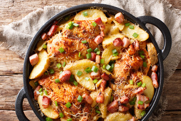 Delicious ranch casserole of chicken fillet with potatoes, bacon and cheese close-up in a pan. horizontal top view