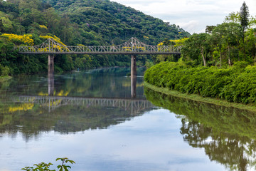 Fototapeta premium Old iron bridge and granite pillars on the Itajai-Açu river in Blumenal, Santa Catarina