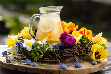 lemonade in a jug on a background of flowers
