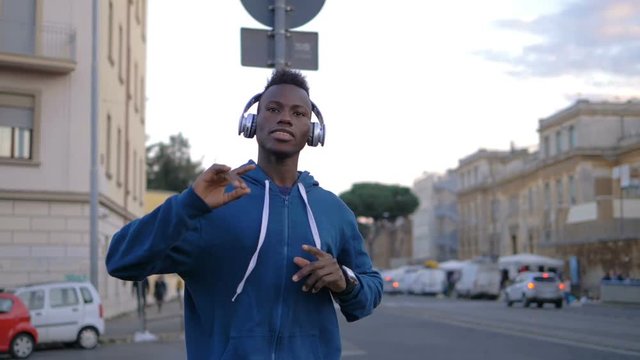 Urban young african migrant dancing, listening music in the city