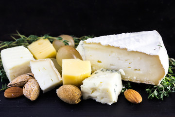 Tasty food background. Cheese with grapes, almond and thyme.