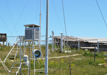 Weather station at the top of the mountain against the blue sky and grass on a Sunny summer day