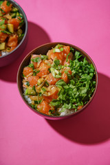 Poke bowl with marinated salmon and vegetable salad on rice