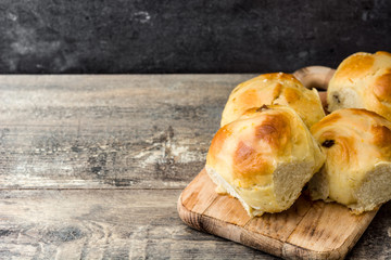 Traditional Easter hot cross buns on wooden table. Copyspace