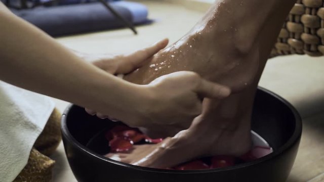 Woman washing beautiful legs in bowl.
