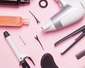 Hair styling and care items and products on pink background