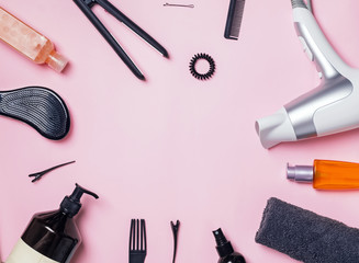 Hair styling and care items and products on pink background