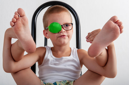 Child in glases with green Occluder. Ortopad Boys Eye Patces nozzle for glasses for treating strabismus (lazy eye).Nine years old boy with one eye covered by eye pad and with eye glasses.