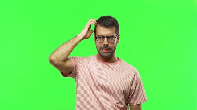 man having doubts while scratching head  on green screen chroma key background