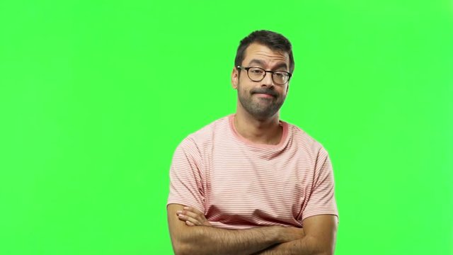 man making unimportant and doubts gesture while lifting the shoulders and the palms of the hands  on green screen chroma key background