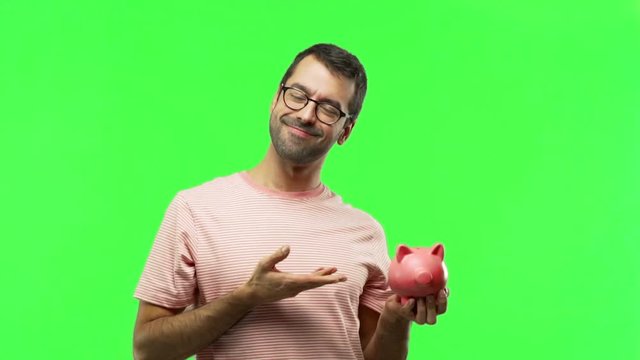 man holding a big piggybank  on green screen chroma key background