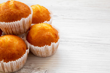Fresh muffins on a white wooden background, side view. Copy space.