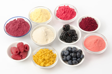 Verschiedene Fruchtpulver und Früchte