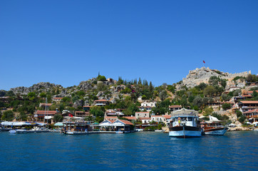 Fototapeta na wymiar Cute houses on the south coast of Turkey. View from the sea to the pier, near the island of Kekova.