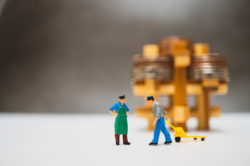 Miniature people, couple man working with stack coins background using as logistic, business and finance concept
