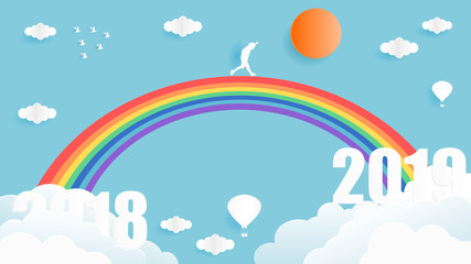 Paper art style vector illustration graphic design of young man walking on the rainbow from year 2018 to year 2019 over the sky.