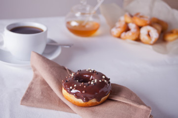 Fresh chocolate donut with cup of coffee on the table