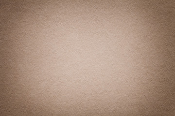 Texture of old light brown paper background, closeup. Structure of dense beige cardboard.