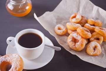 Fresh mini donuts with cup of coffee on the wooden table
