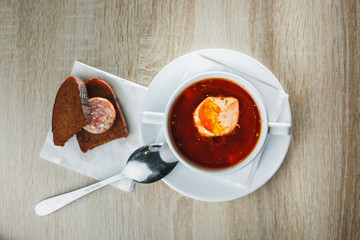 Ukrainian traditional borsch. Russian vegetarian red soup in white bowl on red wooden background. Top view. Borscht, borshch with beet