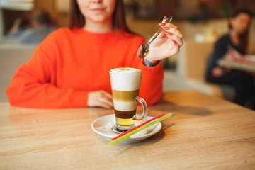 Young woman in light pink clothing holding summer cold strawberry donut freakshake drink with whipped cream in mason jar in hand, selective focus, vertical composition