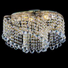 Chandelier made of yellow metal and crystal. Isolated object on a black background