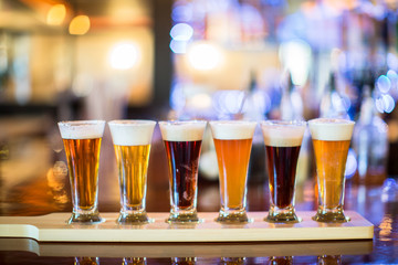 A flight of beer on a bar.