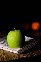 green apple with shadow on the old wood chopping board in the kitchen room - background