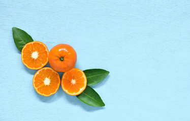orange and leaf on blue board with shadow - background