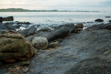 Fototapeta na wymiar Wide view of smoothened stones on the rocky shores of Khao Laem Ya during a blue sunset. Rayong, Thailand.