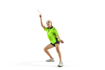 The one caucasian young teenager girl playing badminton at studio. The female teen player isolated on white background in motion