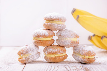 Homemade banana sandwich cookies on a light wooden background