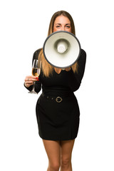 Obraz premium Woman with champagne celebrating new year 2019 shouting through a megaphone to announce something on isolated white background