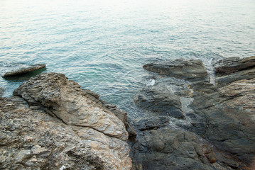 Wide view of rocky shores and calm tides during a blue sunset. Khao Laem Ya, Rayong, Thailand. Travel and nature.